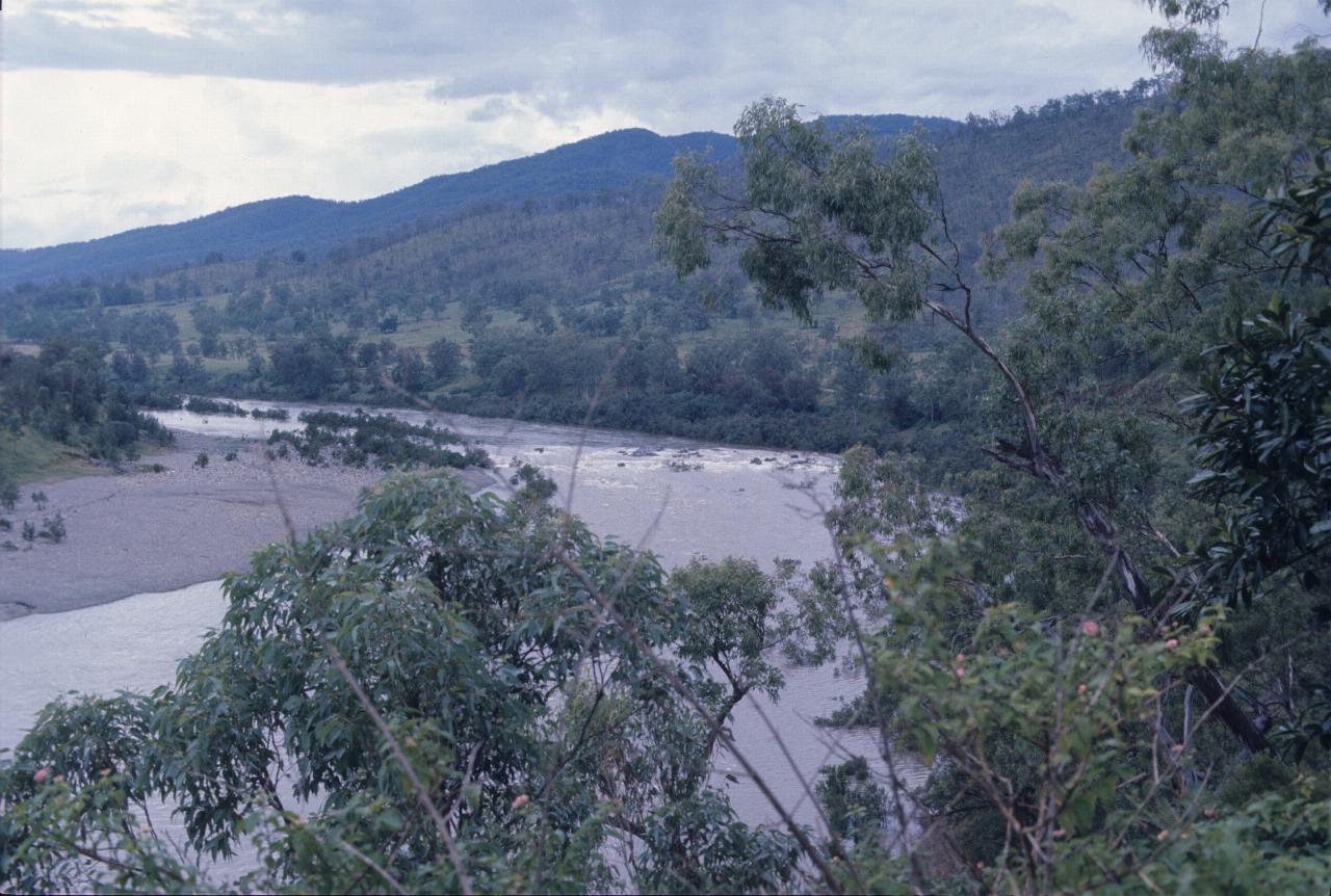 Broad, shallow river bending through farmland and low hills