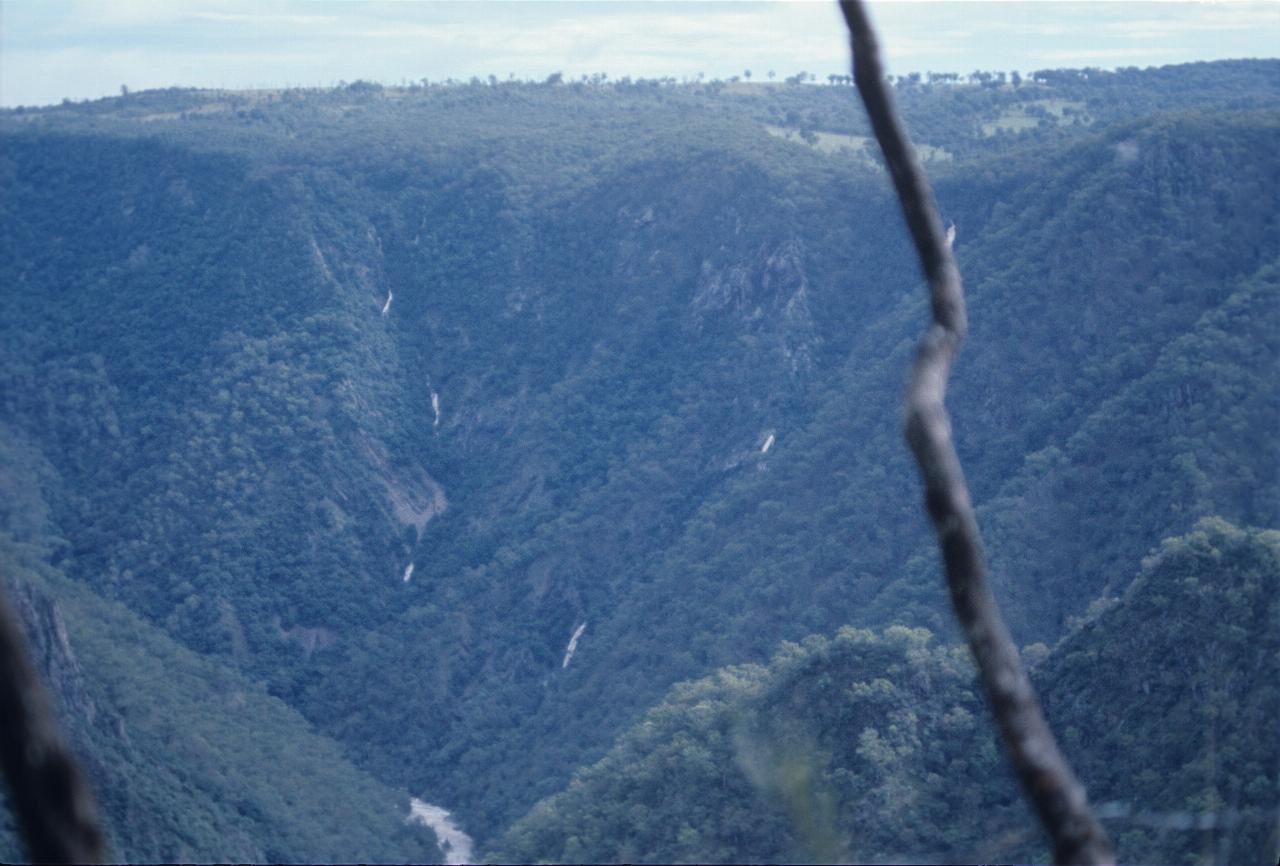 Steep hills, with several small waterfalls on steep, tree covered slopes