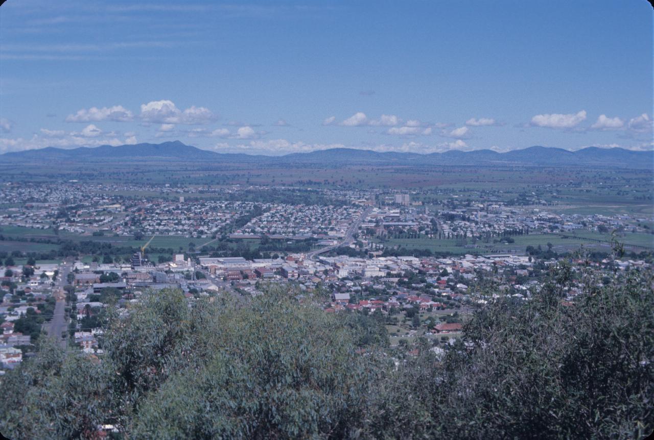 View over large city to farm lands and distant hills