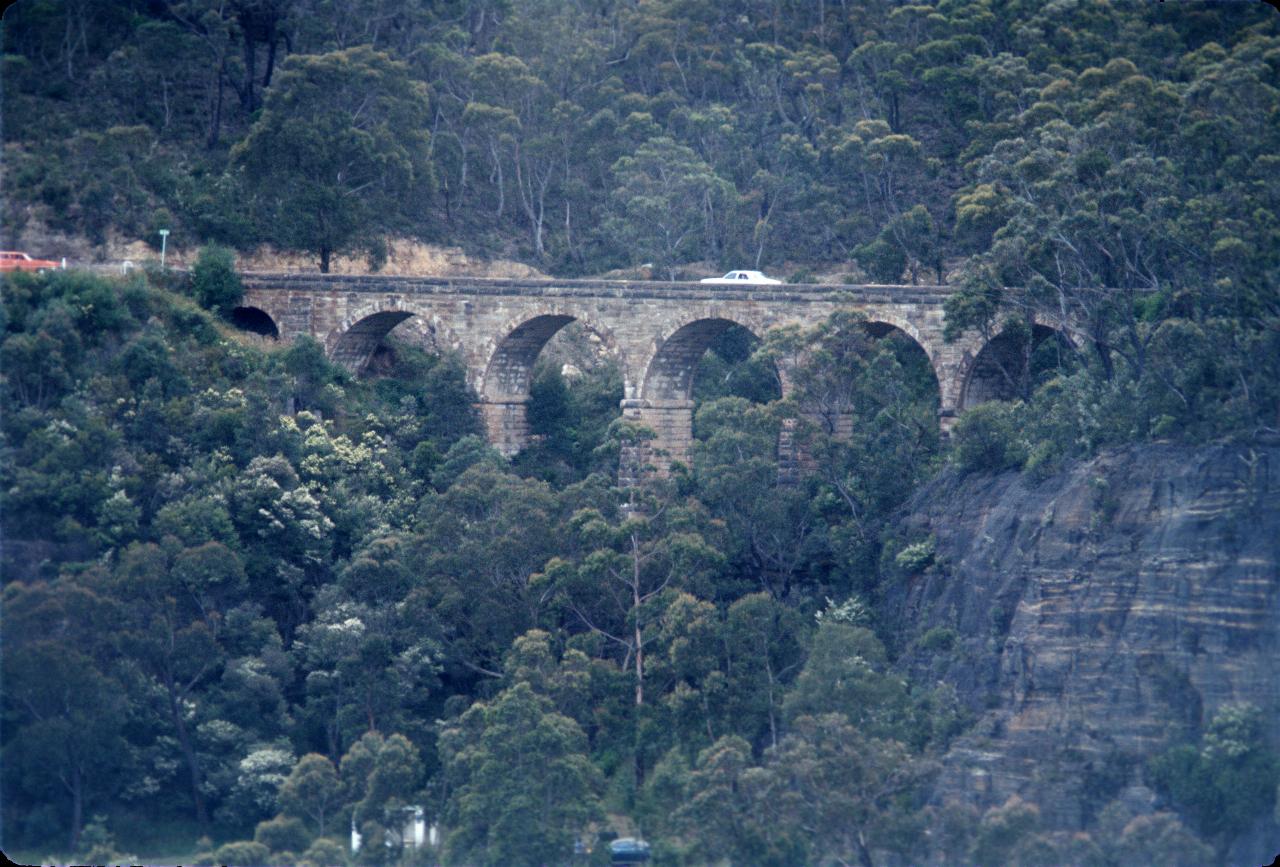 Sandstone block bridge with car crossing and one waiting