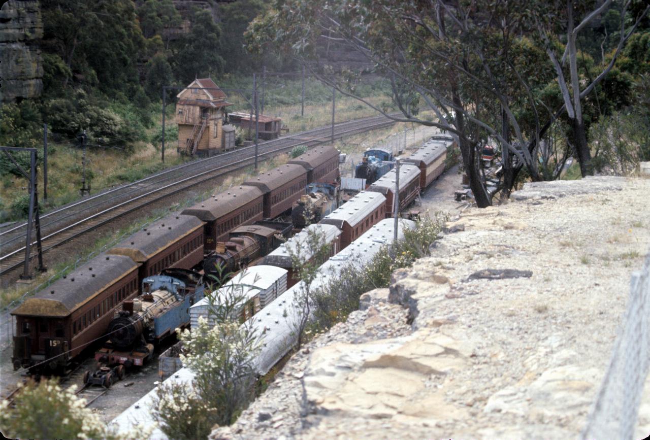 Carriages and locomotives beside mainline; restoration in progress