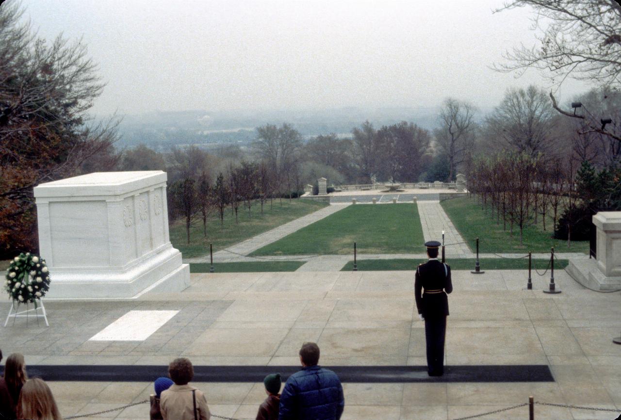 Soldier standing guard over white marble, box shaped tomb