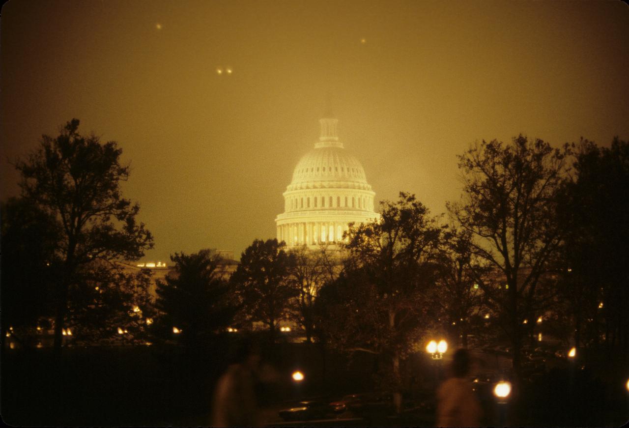 Domed building with pillars on a misty night with park in foreground