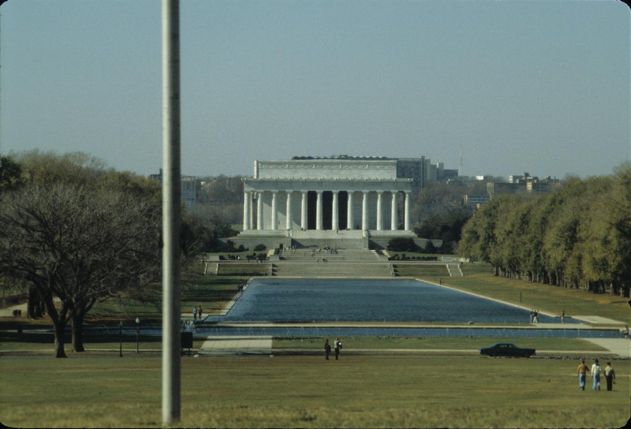 Large white build, with large columns in front, and facing a pool of water