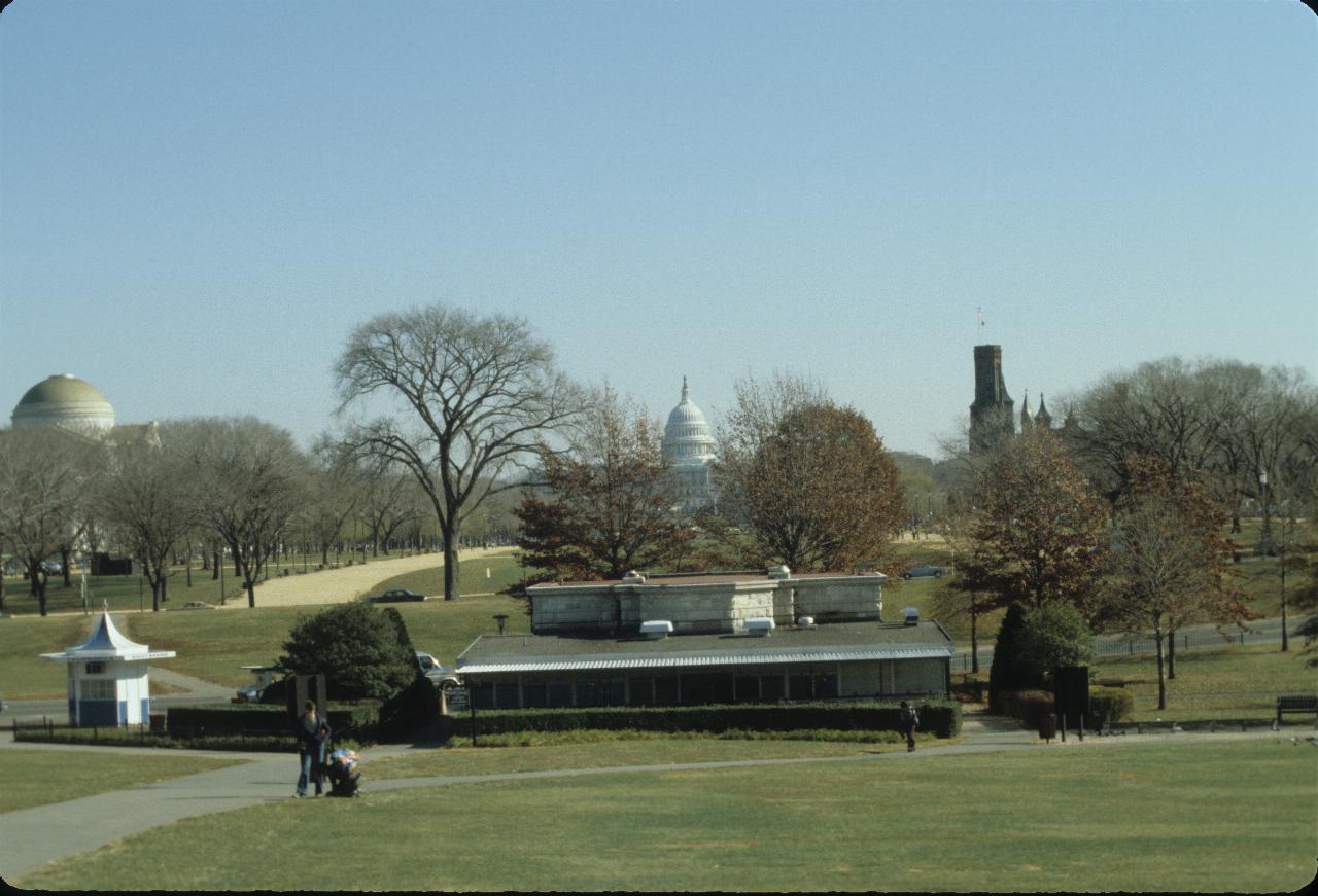 Grassy area, with domed building to left, castle tower to right and tall domed building far back