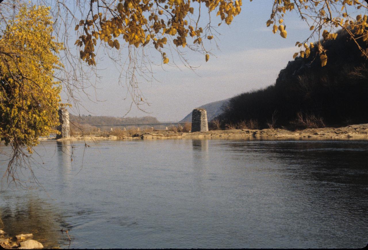 River with stone bridge pillars, but no bridge, with distant bridge downstream