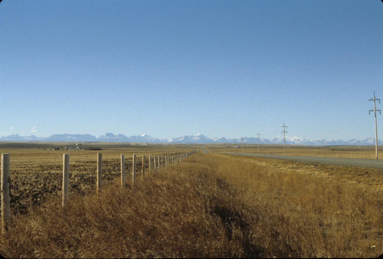 Flat plains, brown grass and distant mountains, snow on peaks