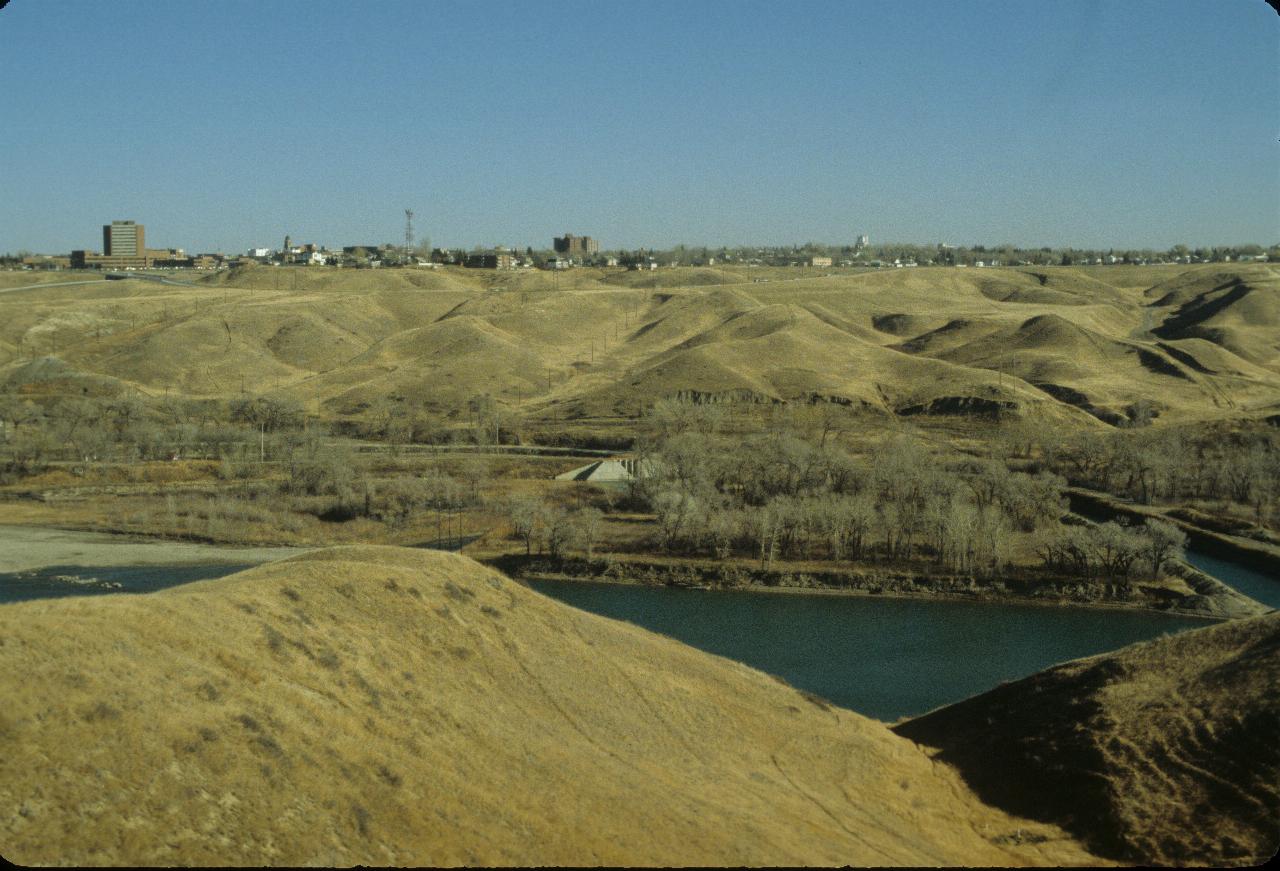 Coulee or small valley in foreground, with city of Lethbridge across the far side