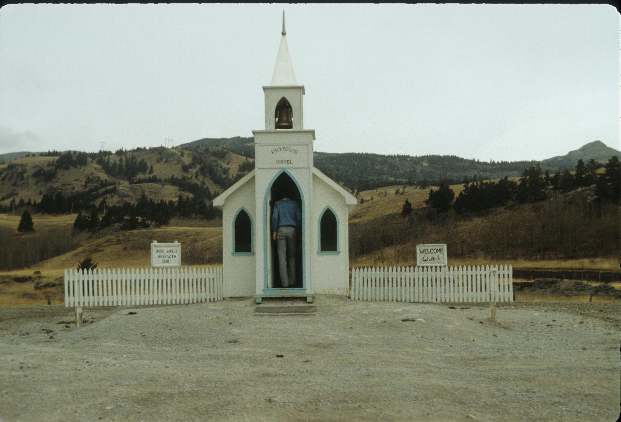 Small white chapel, just big enough to walk in, by the side of the road