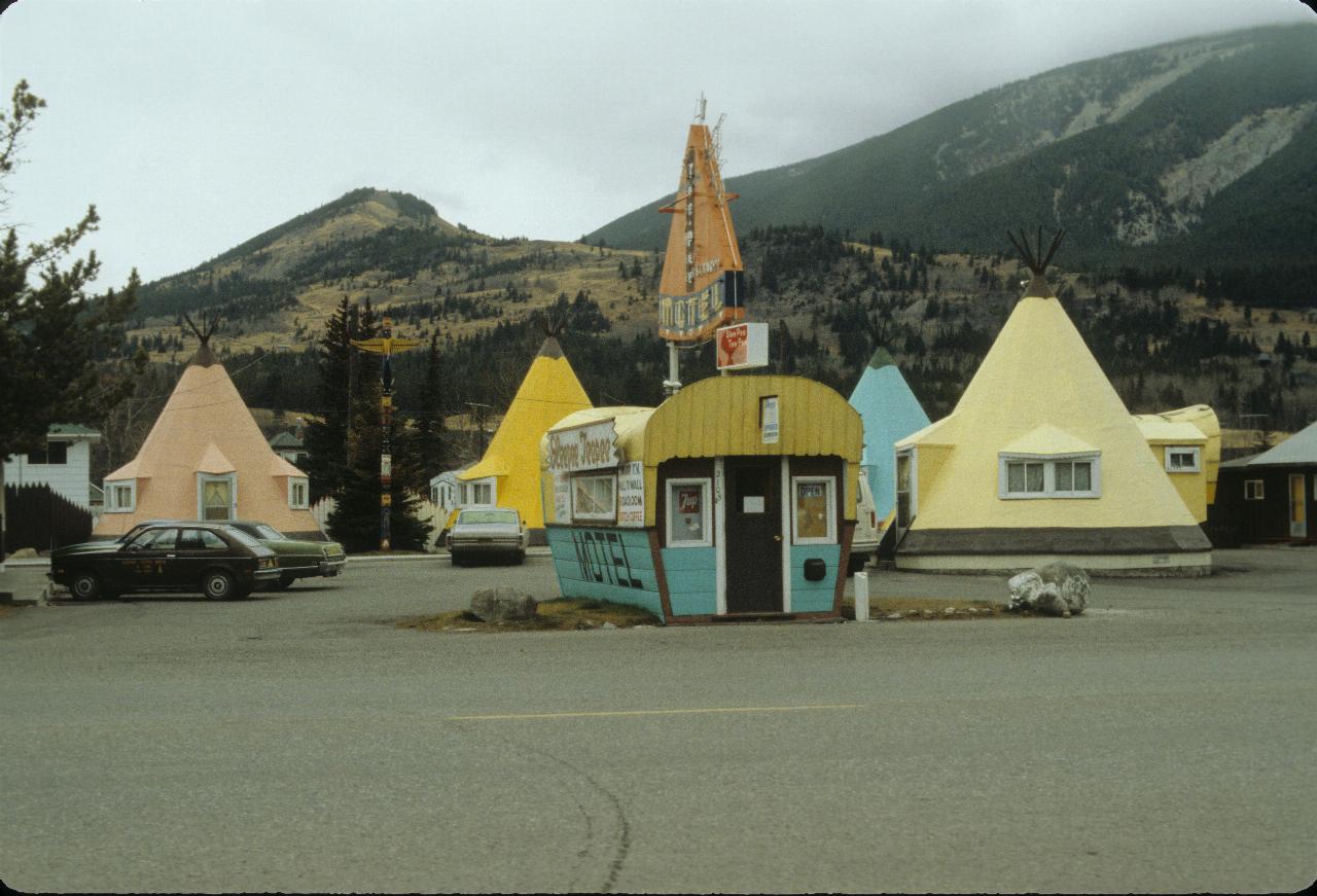 Motel with office building in the shape of a covered wagon and rooms in teepee shape.