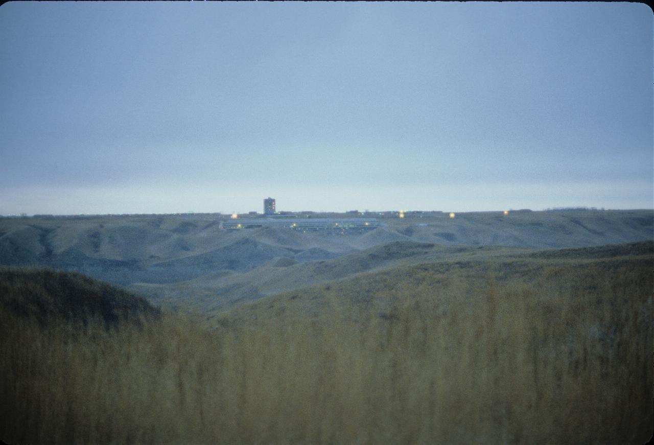 View across coolee to long, low building with dusk settling in