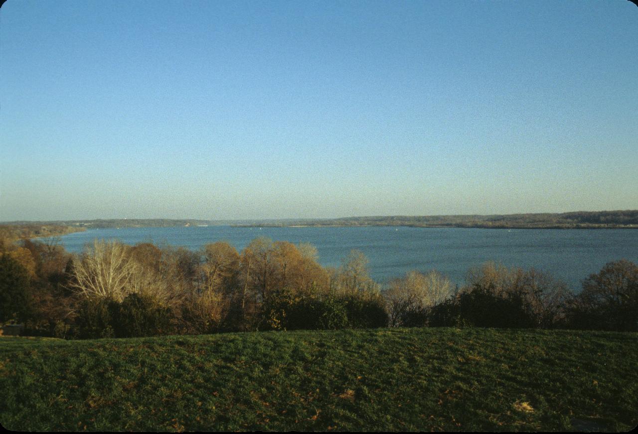 Wide expanse of water below grass and trees