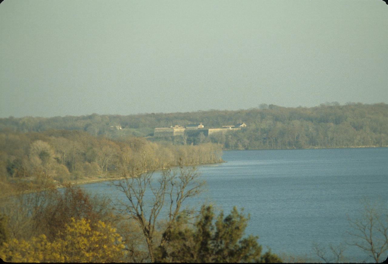 Forested area across the water, with a fort amidst the trees