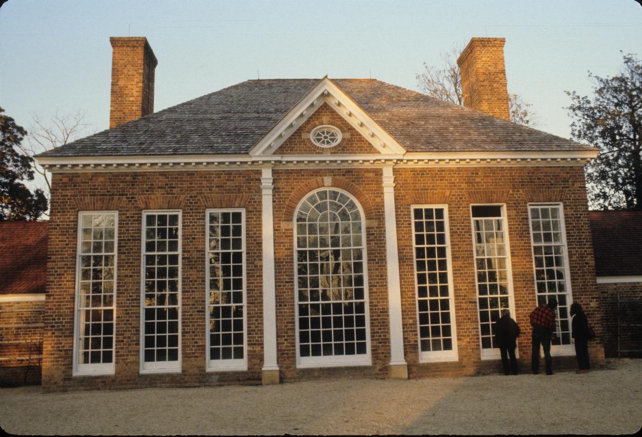 Grand brick building with very tall windows and dual chimneys.