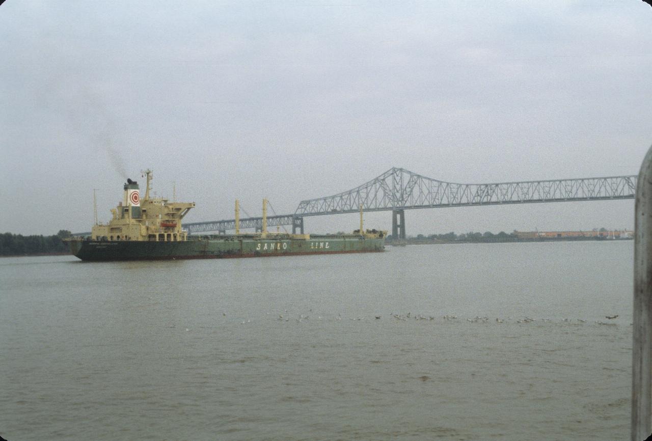 Ship passing under main river bridge for I-10 over Mississippi River in New Orleans