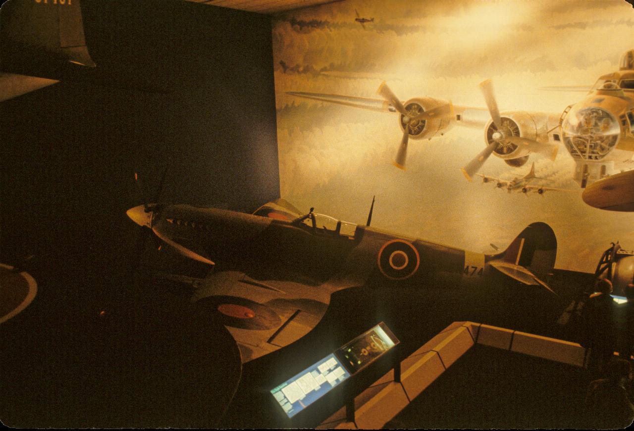 World War II fighter plane in front of wall sized drawing of 4 engined bomber