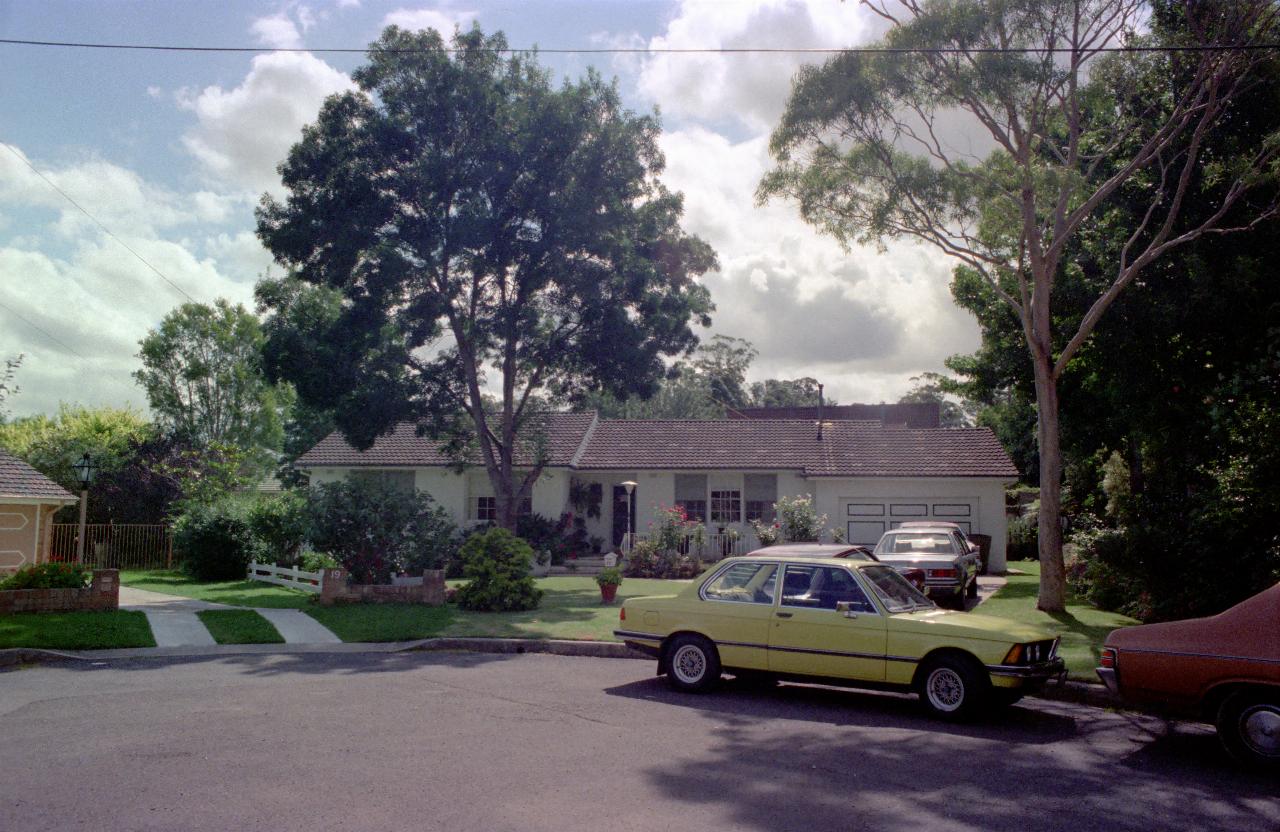 White, ranch style home, well maintained gardens at end of street