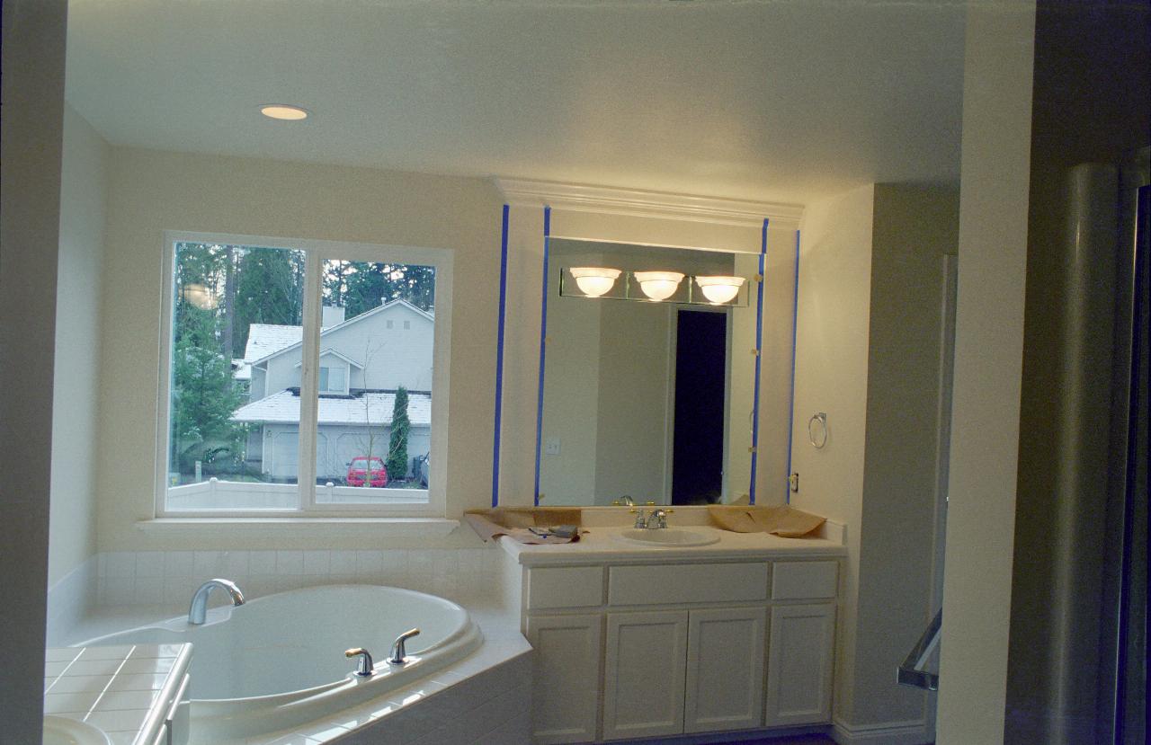 Tub and vanity basin and snowy scene outside window