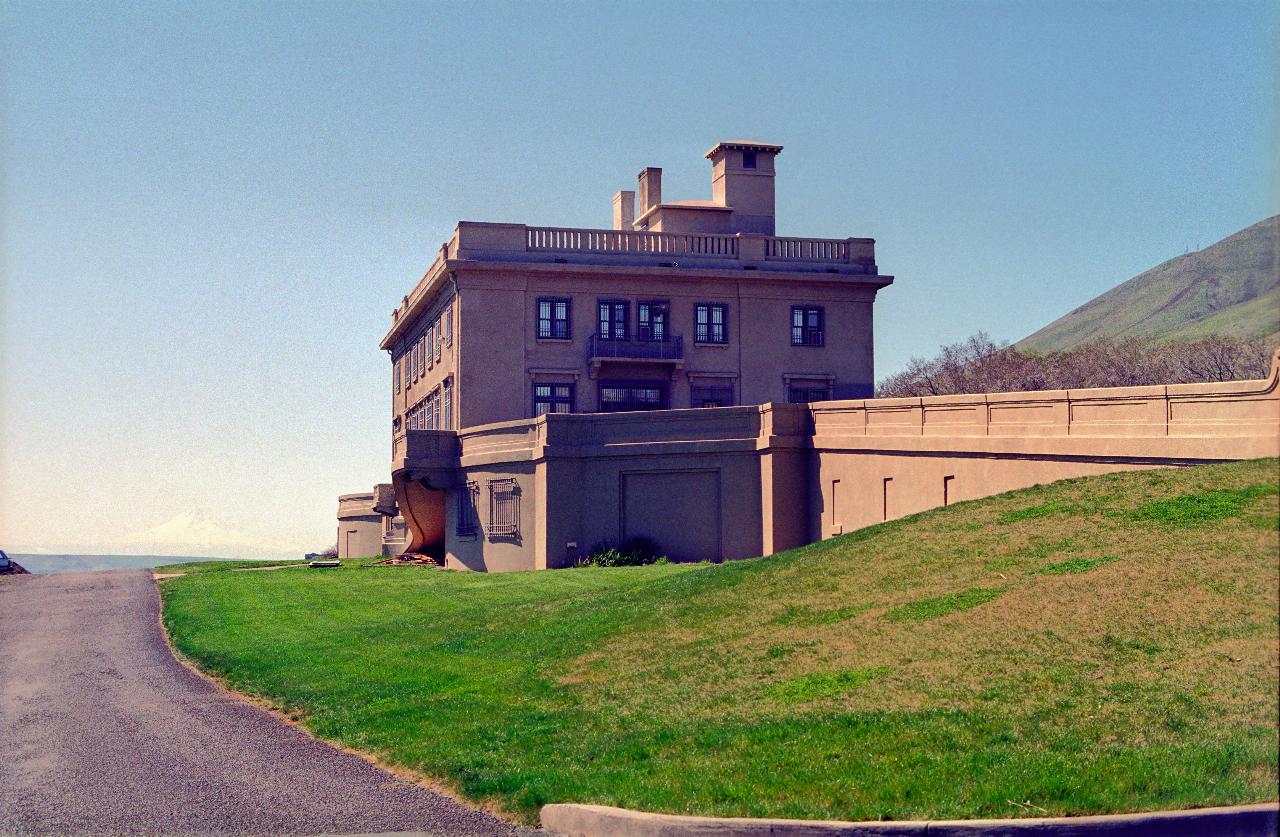 Lightly decorated French style building at base of hills