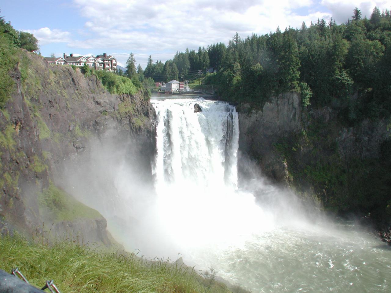 Waterfall falling vigorously between tree lined ridges