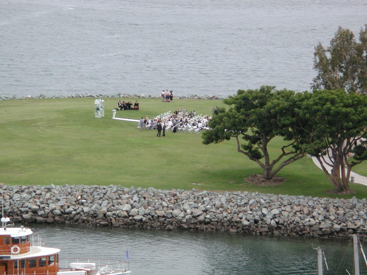 Grassy area between water with seats and arbor