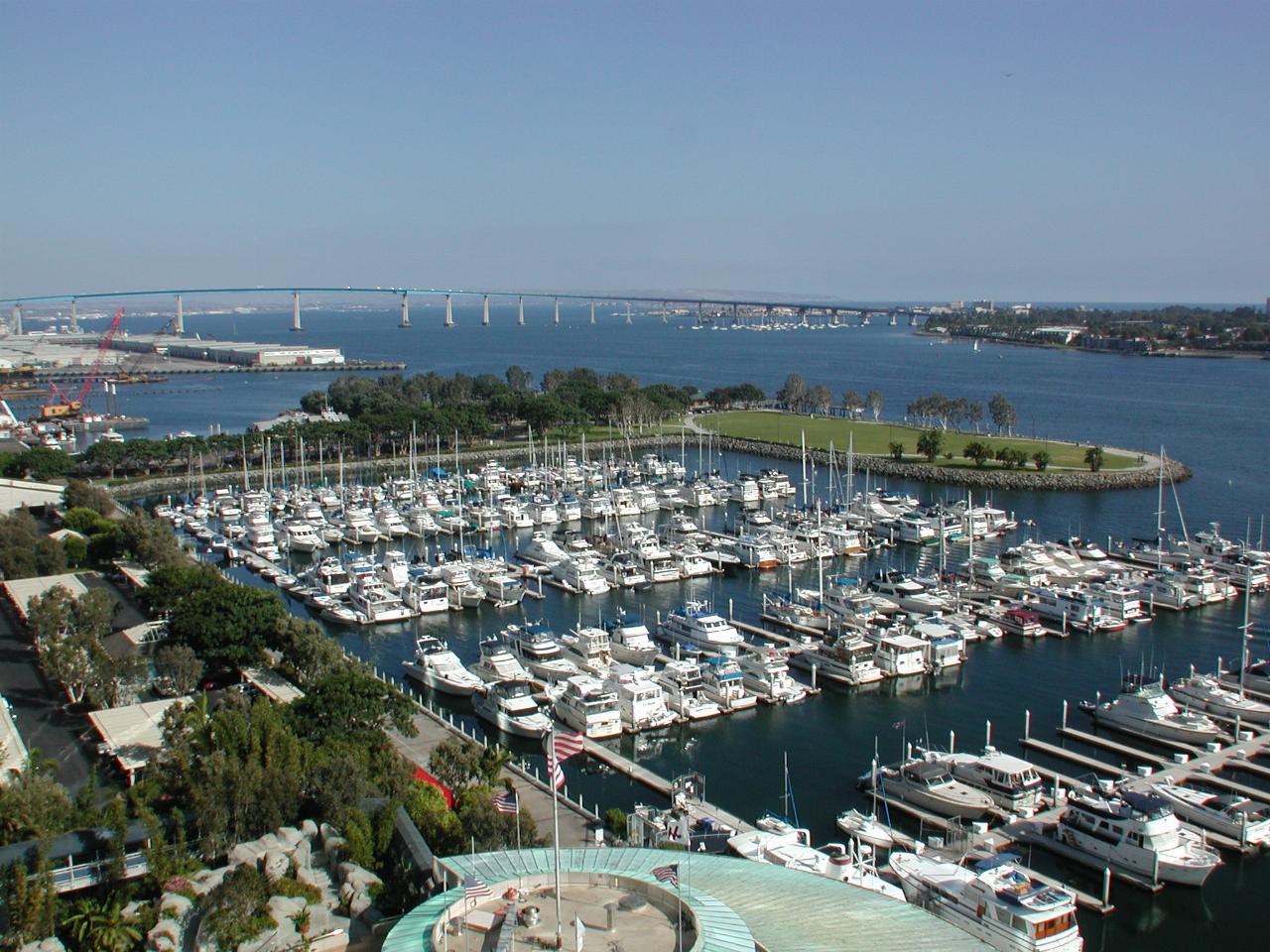 Boating marina on waterway with distant bridge