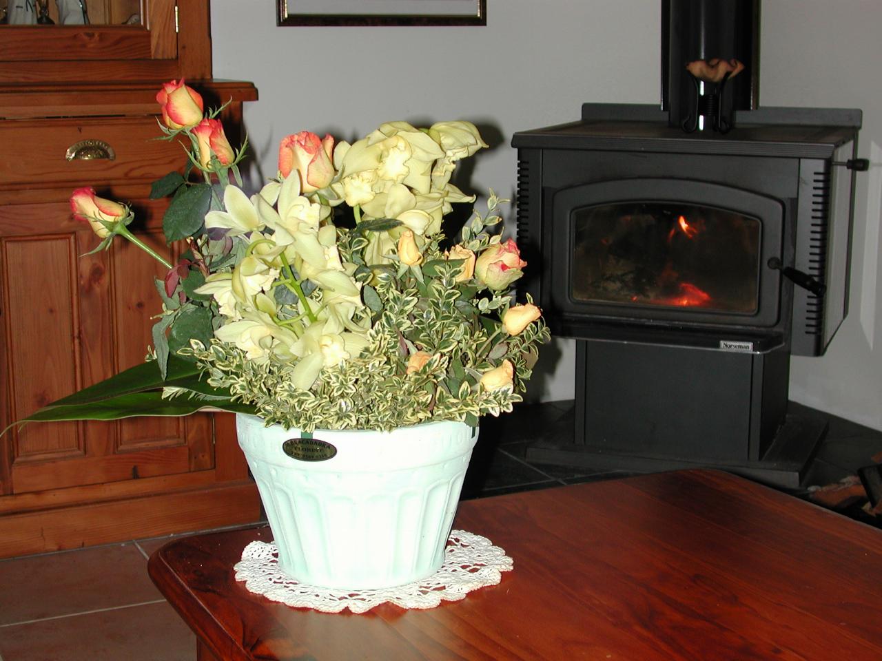 Bunch of flowers on table, wood stove in background