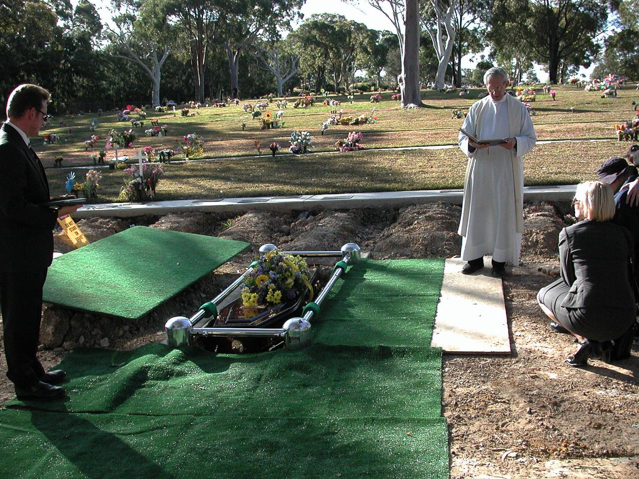 Coffin descending automatically and slowly into the grave