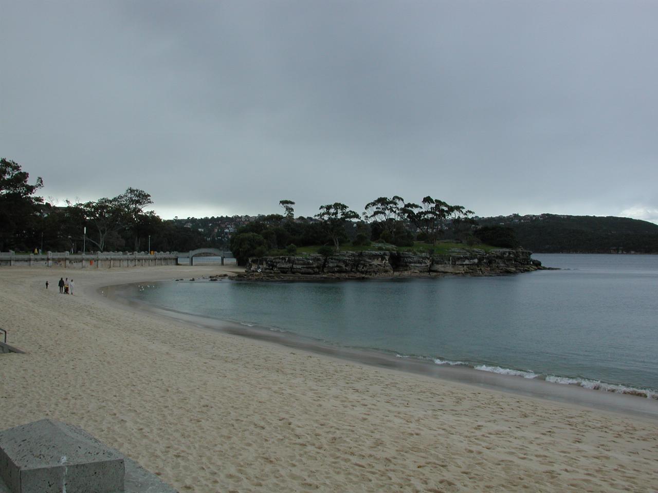 Bush covered, small headland at end of sandy beach