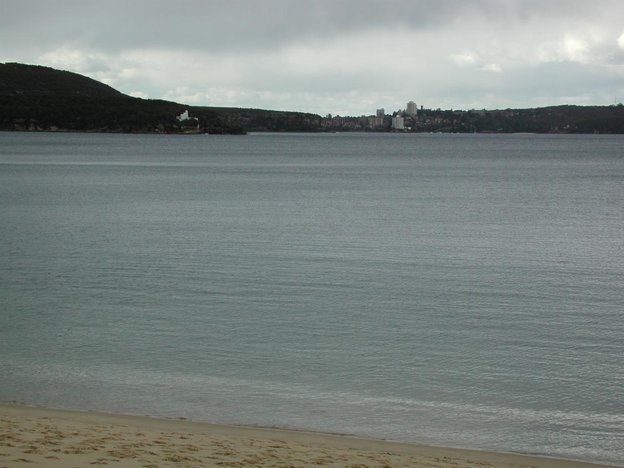 Water view looking to distant tall buildings and bush land