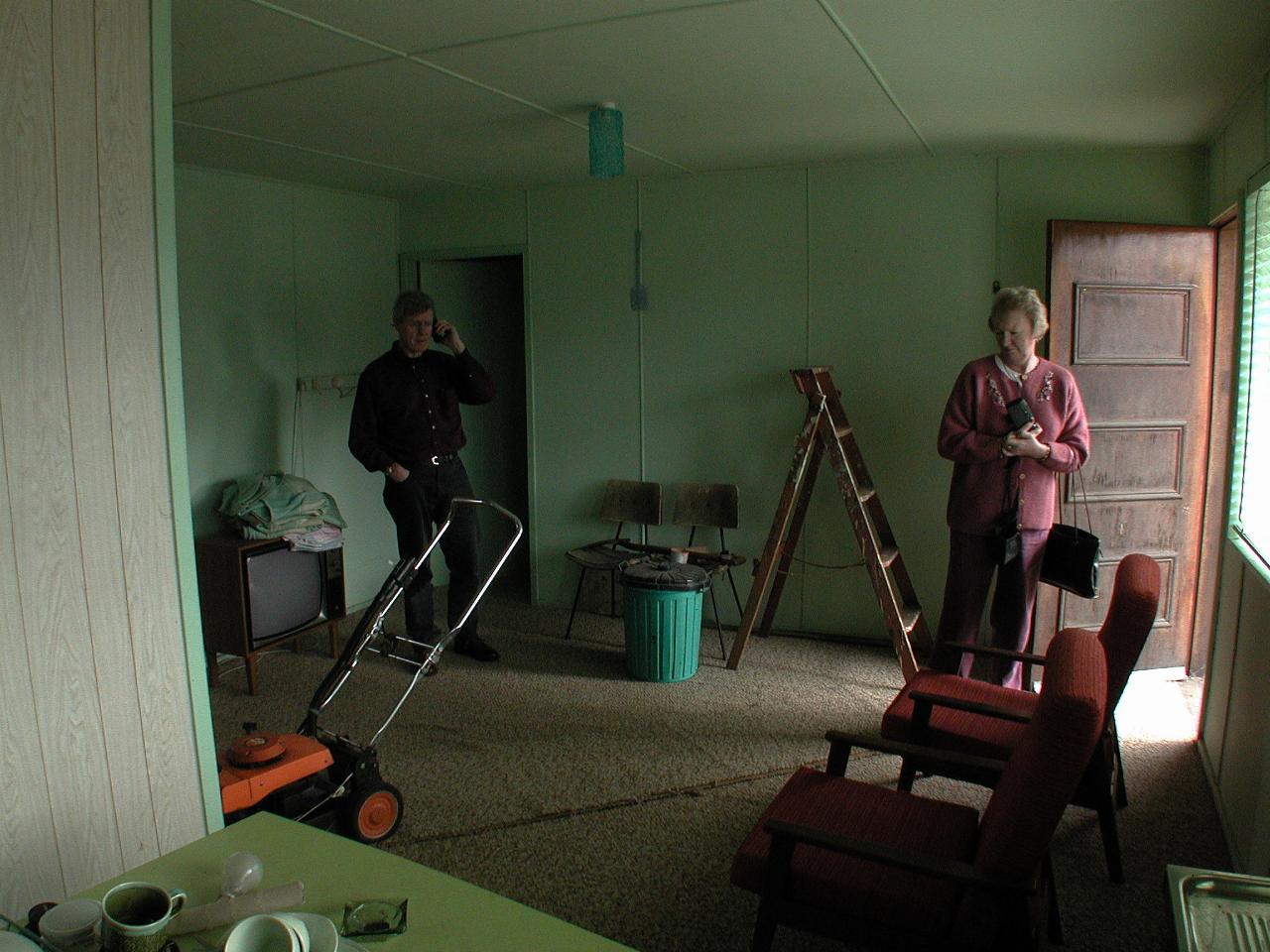 Room with TV, 2 chairs, ladder and lawn mower