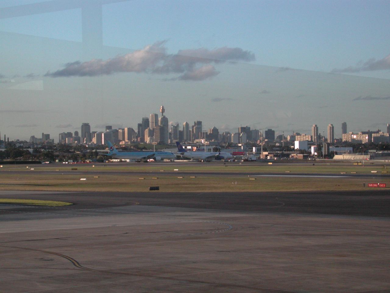 View of downtown with tall buildings seen over airport tarmac