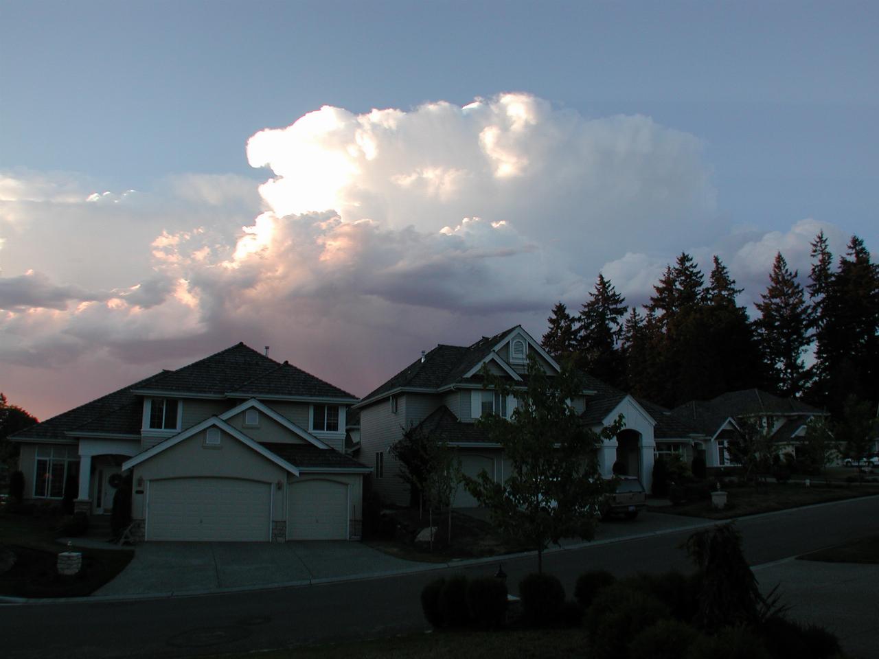 Large storm clouds behind homes across street