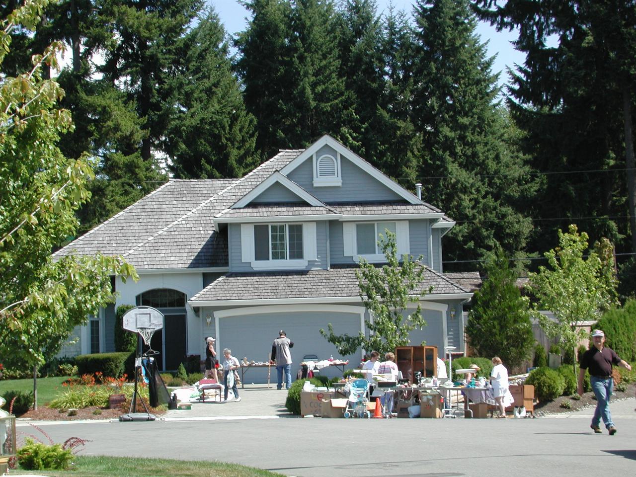 Street scene with cars and people looking at goods for sale