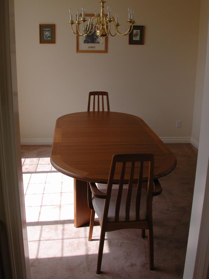 Dining table, circular ends, two chairs, seen from one end