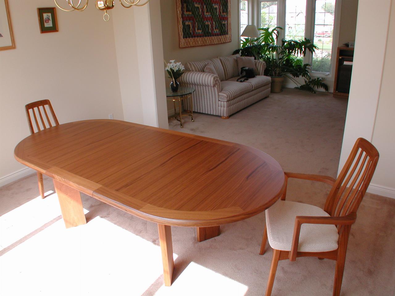 Dining table, circular ends, two chairs, living room beyond