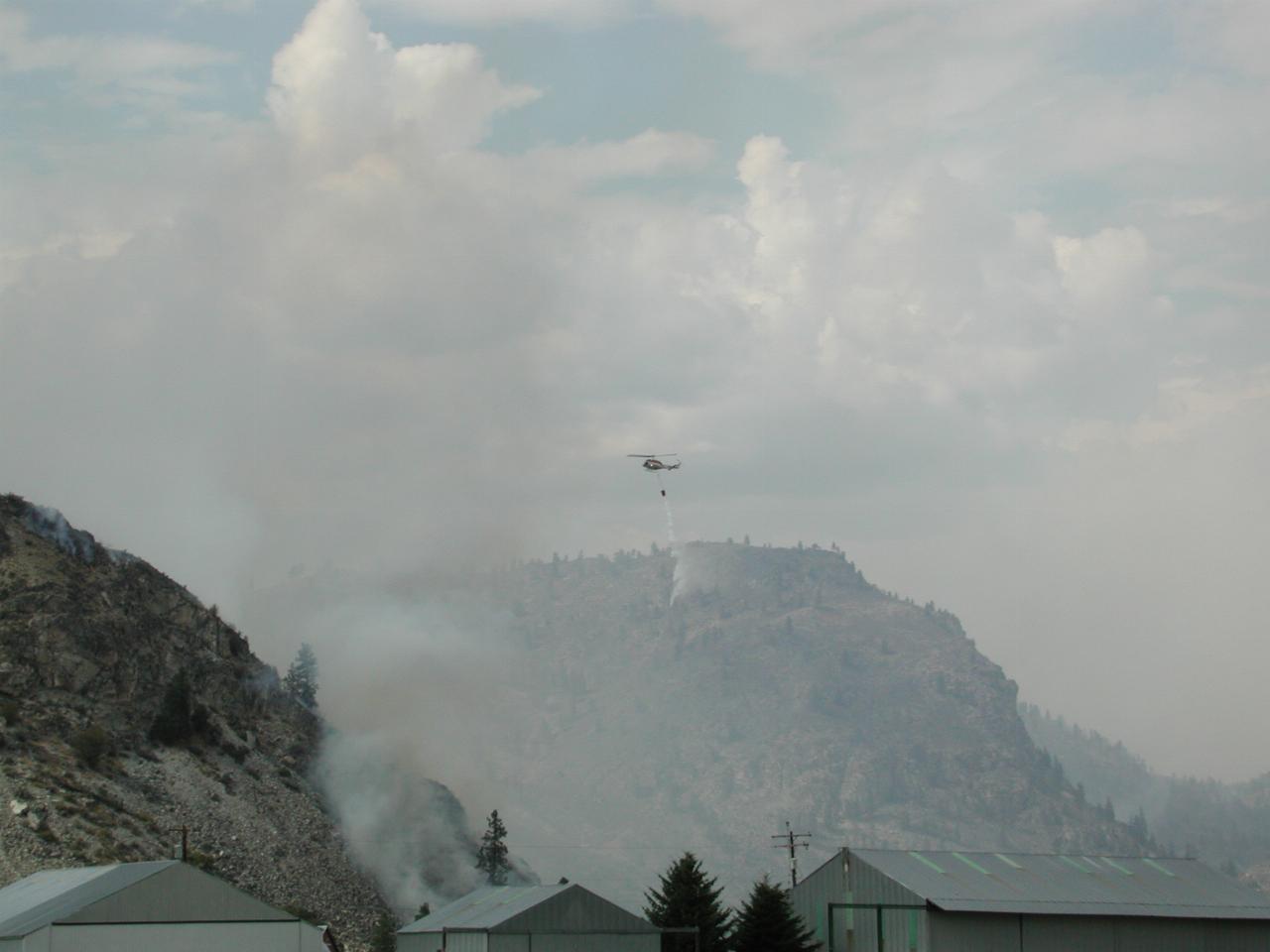 Helicopter dropping water from bucket (water from nearby Columbia River)