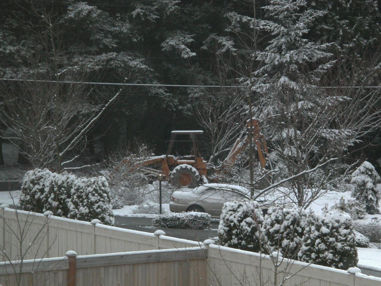 Snow covered tractor waiting to resume garden rebuild