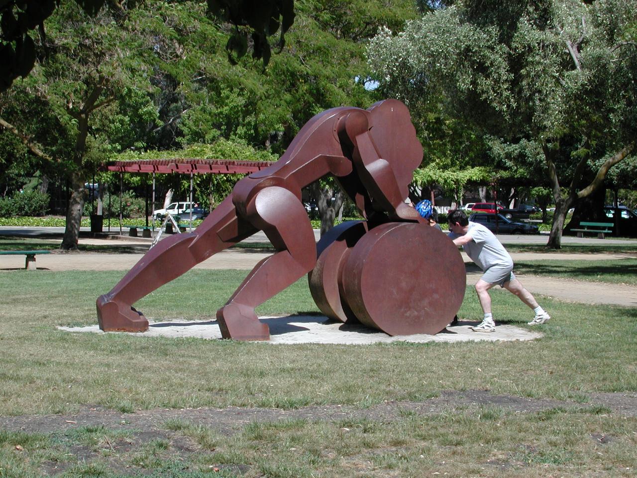 Andrew and Michael pushing against the sculpture