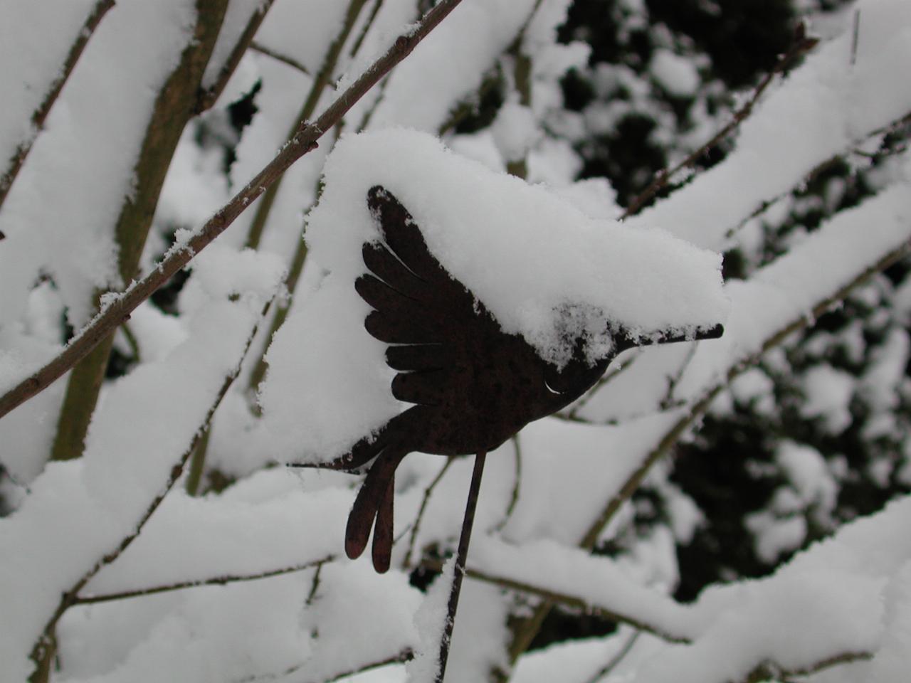 The metal bird all covered in snow