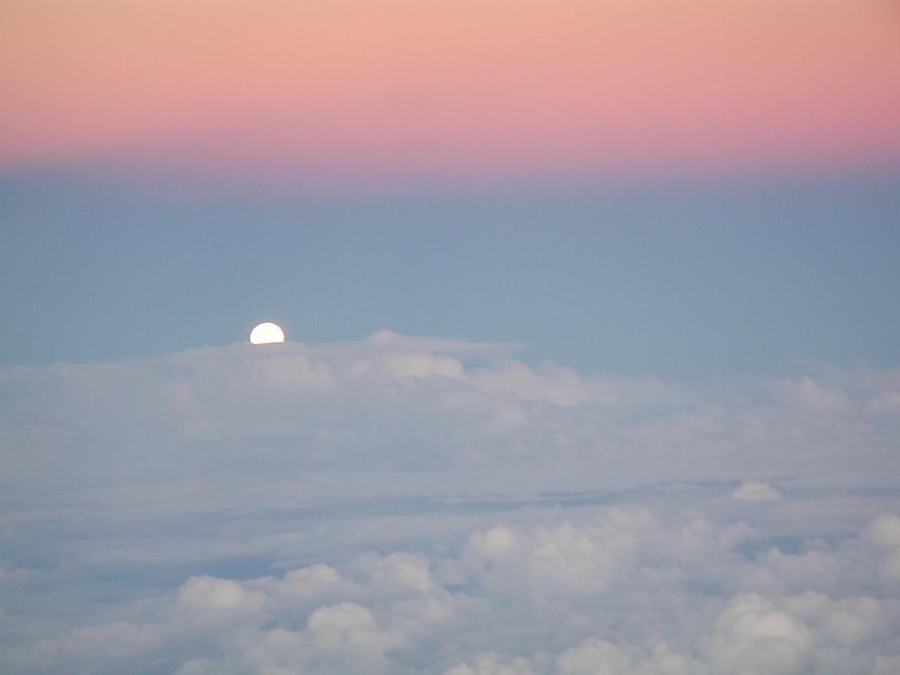 Moon rising over clouds