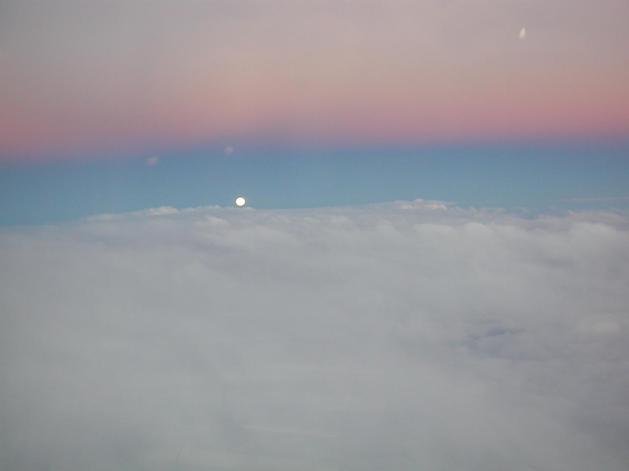 Moon rising over clouds