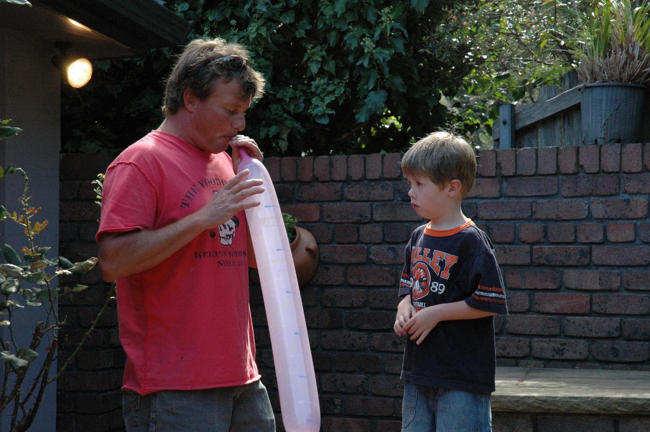 Cameron, watched by Jake, blowing up special balloons at Nat's farewell to London