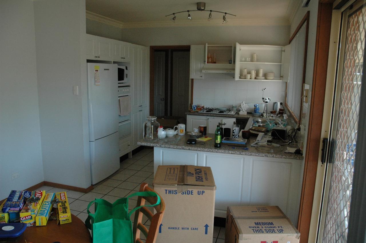 Kitchen, partially unpacked after movers bought in 91 boxes