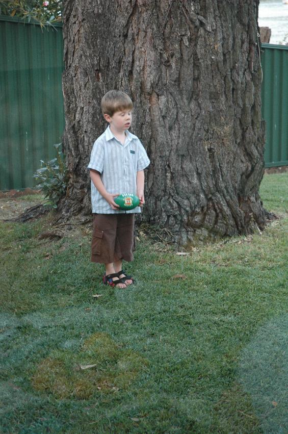 Jake about to kick football after Christmas Eve Mass; at Woronora