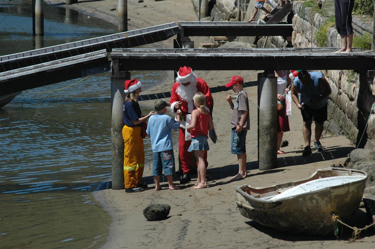 Santa and his helper collecting donations and handing out bags to the kids on Woronora River on Christmas morning