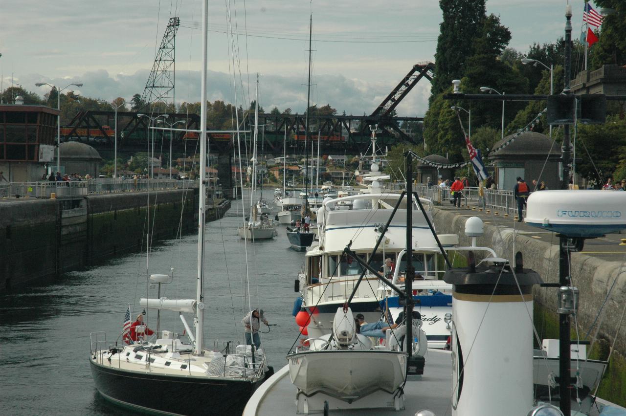 Freight train crossing bridge as large Ballard Lock fills up with pleasure boats