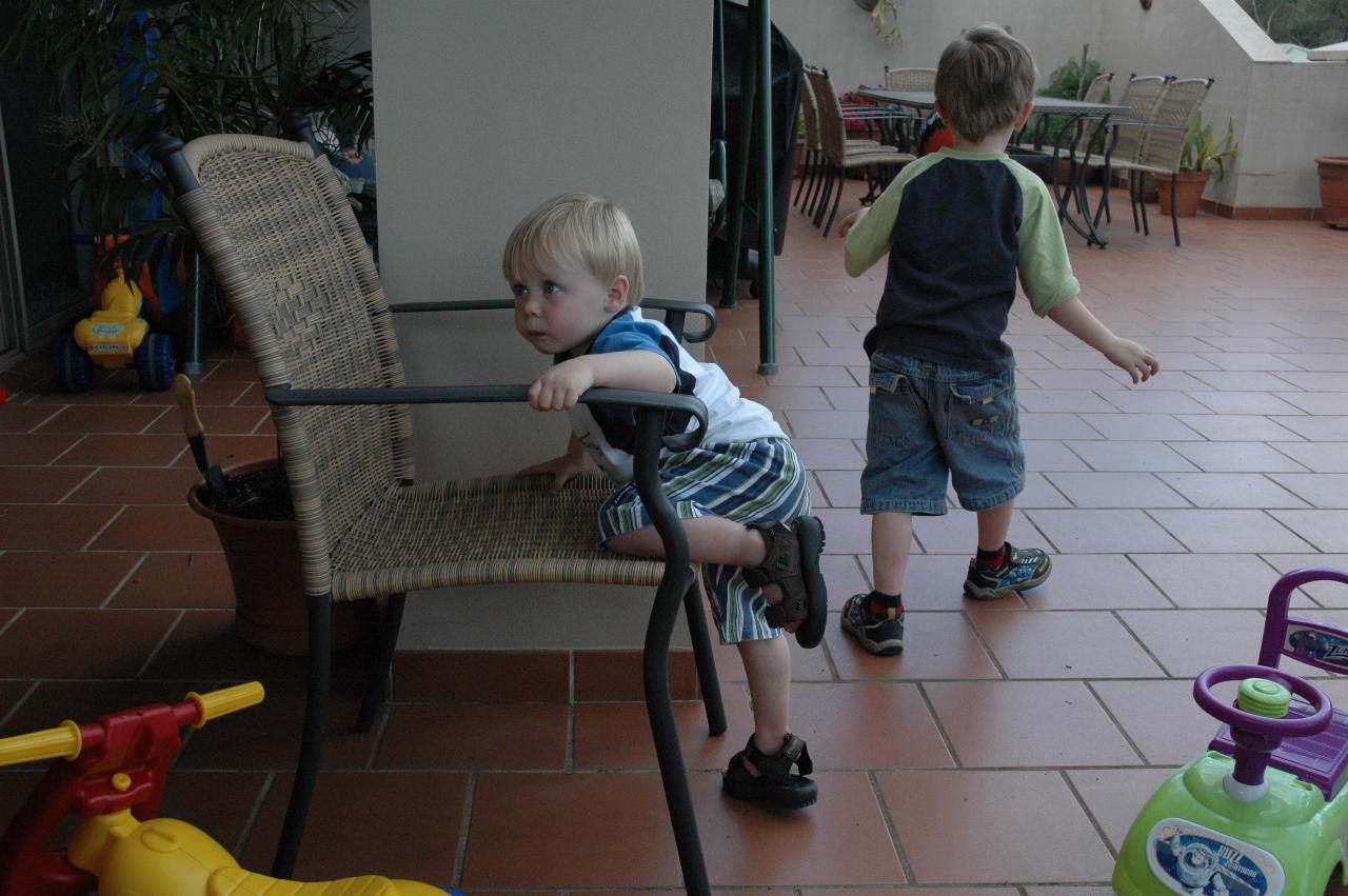 Flynn attempting to climb onto the chair with Jake walking away