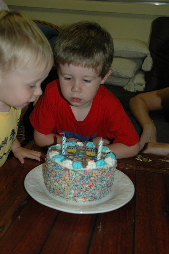 Flynn has just blown out the candles, with assistance from Jake at Flynn's second birthday party