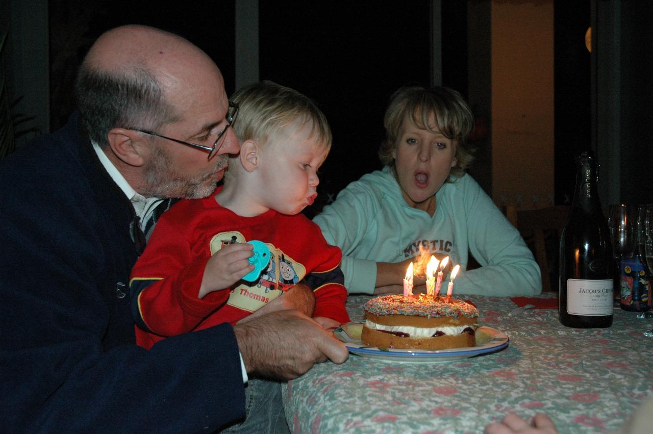 Glenn & Mel's birthday party: Flynn blowing out the candles from Mel's lap